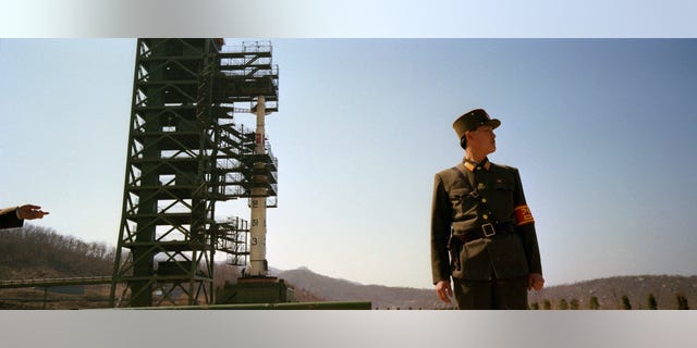 In this April 8, 2012 photo, North Korean soldiers stand guard in front of the country's Unha-3 rocket at Sohae Satellite Station in Tongchang-ri, North Korea. The Kwangmyongsong-3 satellite was launched on April 13, 2012 but failed to reach orbit. (AP Photo/David Guttenfelder)