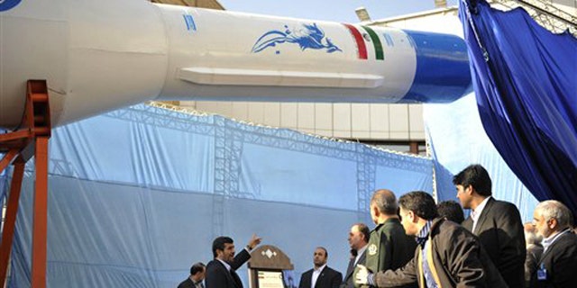 Feb. 3: Iranian President Mahmoud Ahmadinejad, center, gestures towards a model of Iran's domestically-built light booster rocket, named Simorgh -- part of an ambitious space program that has worried Western powers because they fear the same technology used to launch satellites could also deliver warheads.