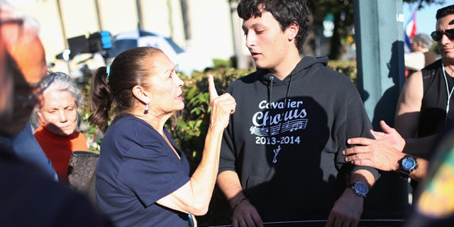 MIAMI, FL - DECEMBER 17: Miriam Clemente speaks with Bryan Medina (R) as he debates her about the new policy laid out by President Barack Obama as they joined people gathered outside the Little Havana restaurant Versailles on December 17, 2014 in Miami, United States. The president annouced he wants to normalize relations with Cuba. (Photo by Joe Raedle/Getty Images)