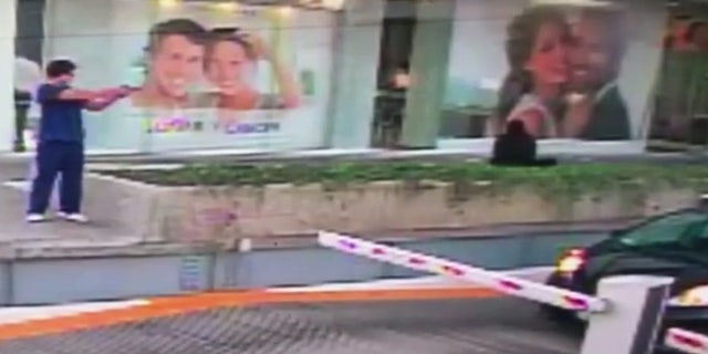 A gunman fires a shot at the car of a U.S. Consulate official in this still from a surveillance video.