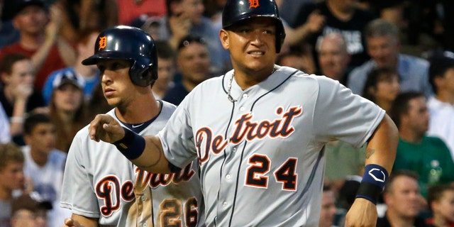 Detroit Tigers' Miguel Cabrera, right, grimaces after scoring with Hernan Perez, left, on a single by Victor Martinez, off a pitch by Chicago White Sox starting pitcher Chris Sale, during the fifth inning of a baseball game Monday, July 22, 2013, in Chicago. Cabrera left the game in the bottom of the fifth. (AP Photo/Charles Rex Arbogast)