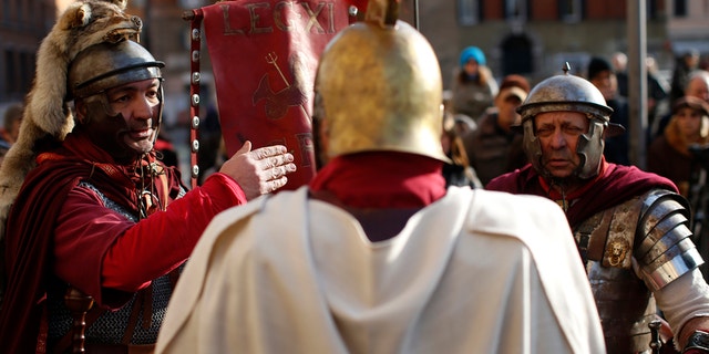 Members of Roman historical society "Gruppo Storico Romano" talk before taking part in a re-enactment of the "Ides of March", known also as the date on which Julius Caesar was assassinated in 44 BC, in downtown Rome.