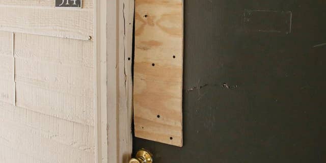 The boarded-up door of an apartment where Oklahoma City police have arrested a mother on suspicion of stabbing a man and her two children, the youngest of which was pronounced dead when police arrived on scene, is pictured in Oklahoma City, Monday, July 11, 2016. (AP Photo/Sue Ogrocki)