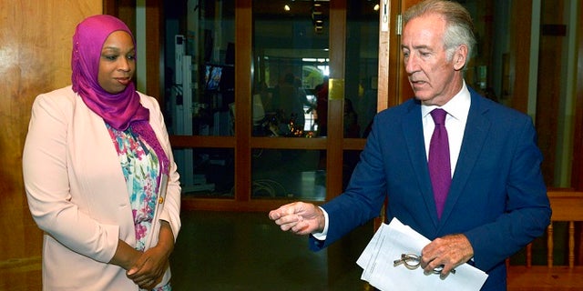 Democratic Rep. Richard Neal flips a coin to determine speaking order as challenger Tahirah Amatul-Wadud looks on before their primary debate at WGBY TV in Springfield, Mass., Thursday, Aug. 30, 2018.