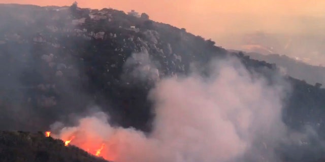 In this image taken from video provided by the Santa Barbara County Fire Department, a wind driven spot fire burns on the west side below Gibraltar Road as smoke from a wildfire fills the air in Santa Barbara, Calif., Saturday, Dec. 16, 2017.