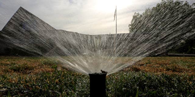 July 15, 2014: Sprinklers water a lawn in Sacramento, Calif.