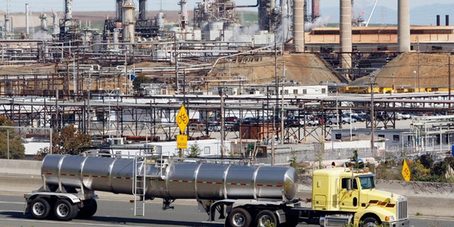 In this March 9, 2010 file photo, a tanker truck passes an oil refinery in Richmond, Calif.