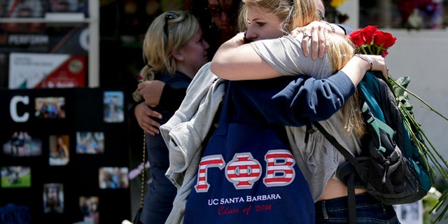 May 27, 2014: Mourners hug in front of the IV Deli Mart, where part of Friday night's mass shooting took place in the Isla Vista area near Goleta, Calif.