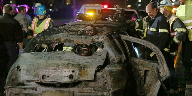 FILE: May 4, 2013: San Mateo County firefighters and California Highway Patrol personnel investigate the scene of a limousine fire on the westbound side of the San Mateo-Hayward Bridge in Foster City, Calif.