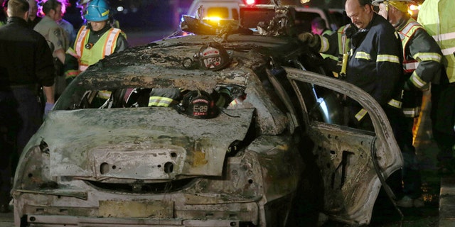 FILE: May 4, 2013: San Mateo County firefighters and California Highway Patrol personnel investigate the scene of a limousine fire on the westbound side of the San Mateo-Hayward Bridge in Foster City, Calif.