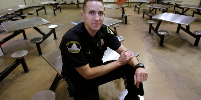 In this Wednesday, Aug. 14, 2013, photo, Sacramento County Deputy Sheriff Kenny Gouveia poses in the housing unit where he was attacked and injured while trying to settle a dispute between two inmates at the Sacramento County Jail. Gouveia was off work for five days while he recovered from the injuries sustained when a 26-year-old inmate attacked him, slamming his head into a food cart and choking him. County jails across California have seen a marked increase in violence since they began housing thousands of offenders who previously would have gone to state prisons.