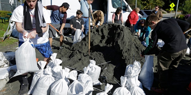 People load sand bags in preparation for a large storm on Friday, Jan. 6, 2017, in San Anselmo, Calif.