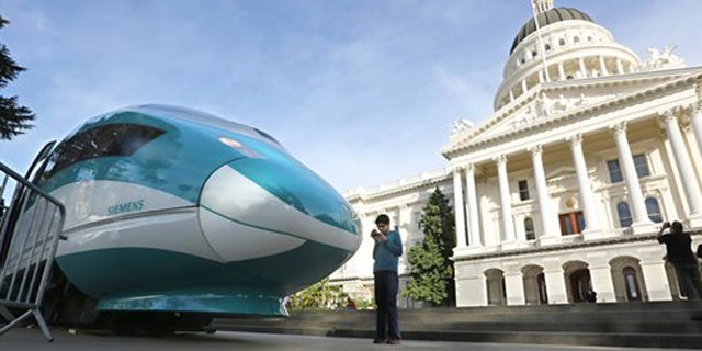 FILE - In this Feb. 26, 2015 file photo, a full-scale mock-up of a high-speed train is displayed at the Capitol in Sacramento, Calif. State officials will return to Sacramento Superior Court, Thursday, Feb. 11, 2016, to defend the project against critics who say high-speed rail cannot meet promises made to voters who approved a $9.9 billion bond measure to build it. (AP Photo/Rich Pedroncelli, File)