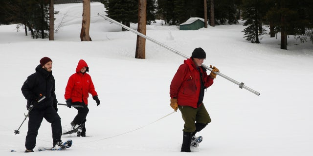 Feb. 2, 2017: Frank Gehrke, right, chief of the California Cooperative Snow Surveys Program for the Department of Water Resources, carries the snowpack measuring tube as he crosses a snow covered meadow while conducting the second manual snow survey of the season in Echo Summit, Calif.