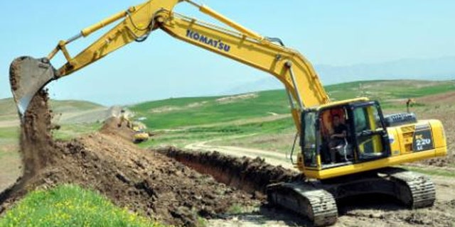 A long ditch Kurds dug last year along their border with Islamic State is largely symbolic and has not stemmed the flow of goods - both ways. (Reuters)