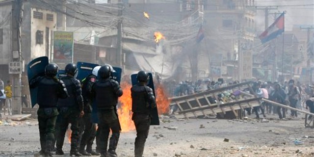 Jan. 3, 2014: Cambodian riot police prepare to confront with garment workers throwing stones and bricks near a factory on the Stung Meanchey complex on the outskirts of Phnom Penh, Cambodia.
