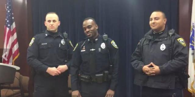 Cambridge Police Officer Andy Cazeau (middle) helped a woman and her husband deliver a baby on New Year's Day.
