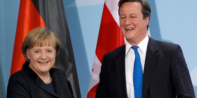 Nov. 18, 2011: German Chancellor Angela Merkel, left, and British Prime Minister David Cameron, right, shake hands after a news conference during a meeting at the chancellery in Berlin, Germany.