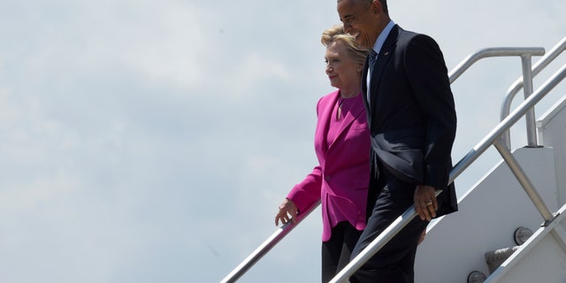 FILE -- July 5, 2016: President Obama and Democratic presidential candidate Hillary Clinton walk down the steps of Air Force One after arriving at North Carolina Air National Guard Base in Charlotte, N.C.
