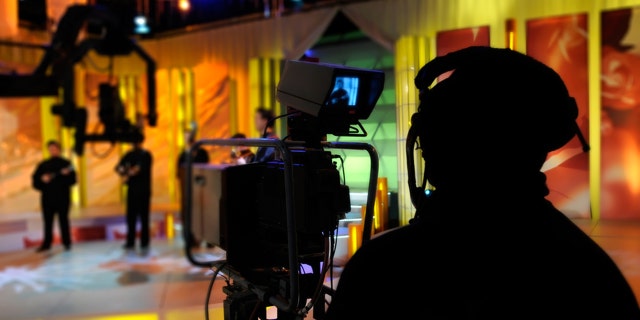 Cameraman works in the studio - recording show in TV studio