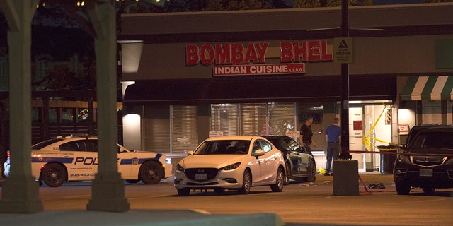 Police stand outside the Bombay Bhel restaurant in Mississauga, Canada Friday.