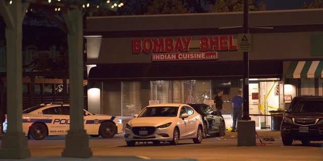 Police stand outside the Bombay Bhel restaurant in Mississauga, Canada Friday.