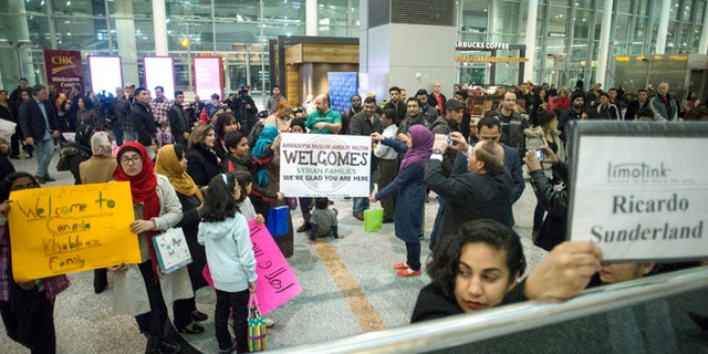 Members of groups who are sponsoring two Syrian refugee families hold up signs welcoming their charges as they wait for the families to arrive at Toronto Pearson International Airport, Wednesday, Dec. 9, 2015, Mississauga, Ontario, Canada. (Chris Young/The Canadian Press via AP) MANDATORY CREDIT