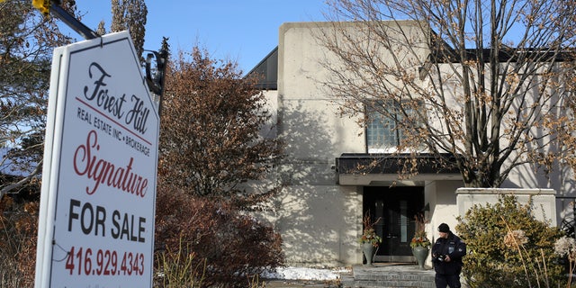 A police forensics photographer works outside the home of billionaire founder of Canadian pharmaceutical firm Apotex Inc., Barry Sherman and his wife Honey after they were found dead in December 2017.