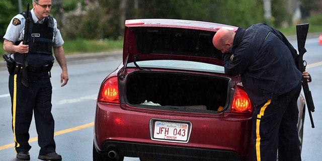 June 5, 2014: Police officers check a car at a roadblock in Moncton, New Brunswick.