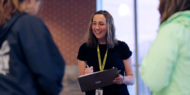Cancer survivor Christine Ells talks with her students as she takes attendance at Quincy High School in Quincy, Mass., Monday, Nov. 9, 2015. Ells, 36, a teacher in the Boston suburb of Quincy, developed a heart rhythm problem from several drugs she was given to treat the breast cancer she was diagnosed with at age 27. (AP Photo/Charles Krupa)