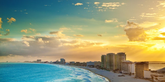 Subject: A panoramic view of the hotel district of Cancun at sunset. A popular tourist beach destination. The Yucatan Peninsula and the Riviera Maya in Mexico is a well developed vacation location with numerous hotels and entertainment districts.
