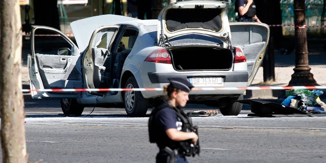 Police secure the area near a burned car at the scene of an incident in which it rammed a gendarmerie van on the Champs-Elysees Avenue in Paris, France, June 19, 2017. (REUTERS/Charles Platiau)