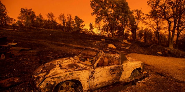 Cars scorched by the Carr Fire rest at a residence in Redding, Calif., on Friday, July 27, 2018