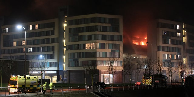 Emergency services attend the scene of a fire at a multi-storey car park on Liverpool's waterfront, north west England, Sunday Dec. 31, 2017. Witnesses said cars seemed to explode every couple of seconds when the fire was at its peak. They said the fire started in an older vehicle and quickly spread. (Peter Byrne/PA via AP)