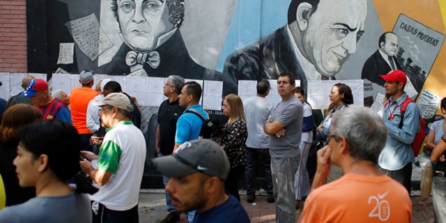 People lineup to enter to a poll station during the election for a constitutional assembly in Caracas, Venezuela, Sunday, July 30, 2017.