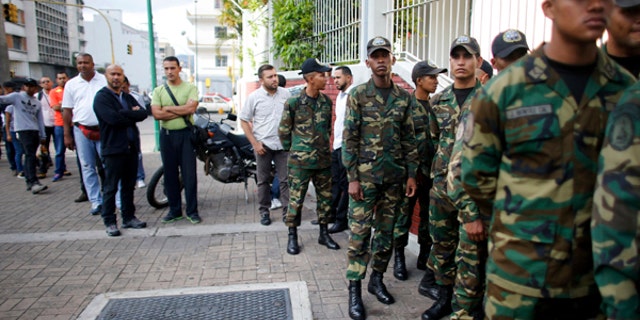 Venezuelan Bolivarian Army soldiers lineup to vote for the constitutional assembly outside of a poll station in Caracas, Venezuela, Sunday, July 30, 2017.