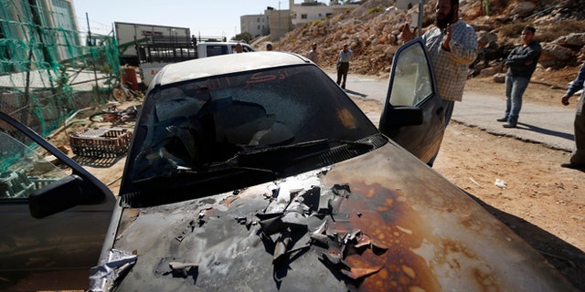 Oct. 10: A Palestinian man gestures near a damaged car in the West Bank village of Burka, near Ramallah. An Israeli police spokesperson said on Thursday three cars were damaged overnight and the words "Geulat Tzion loves Tomer Hazan" were scrawled in Hebrew on a wall of the mosque. Geulat Tzion is an illegal Jewish settler-outpost in the West Bank where structures were demolished by Israeli forces a day earlier and Tomer Hazan is an Israeli soldier who was killed by a Palestinian on September 21.