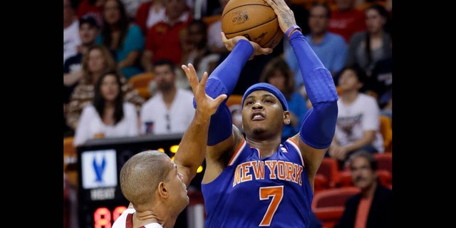 New York Knicks forward Carmelo Anthony (7) takes a shot against Miami Heat forward Shane Battier during the second half of an NBA basketball game, Tuesday, April 2, 2013 in Miami. Anthony tied his career high with 50 points in the Knicks' 102-90 win. (AP Photo/Wilfredo Lee)