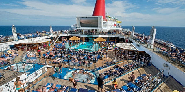 Guests on the Carnival Sunshine soak up the sun on the ship's Lido Deck that features a main pool and two whirlpools. (Andy Newman/Carnival Cruise Lines)