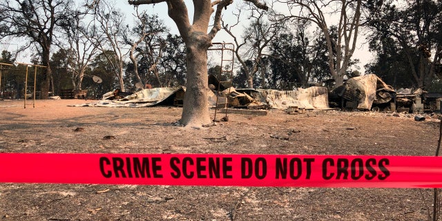 Police tape blocks the house where relatives say three people were found dead following a wildfire in Redding, Calif., Saturday, July 28, 2018.
