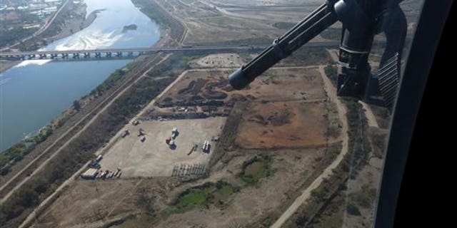 In this March 12, 2014, Mexican federal police fly over the Balsas River near the Pacific port of Lazaro Cardenas, Mexico. Alonso Ancira, president of the National Chamber of the Iron and Steel, told local media that drug cartels earned $1 billion in profits in 2013 from the sale of iron ore, according to his estimates. By 2012 nearly half of the iron ore exports to China went through the port of Lazaro Cardenas. The federal government took over the port of Lazaro Cardenas in November 2013. (AP Photo/Eduardo Castillo)