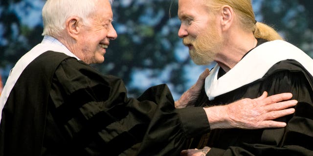 Jimmy Carter hugs Gregg Allman who received an honorary degree at Mercer University in Macon, Ga.