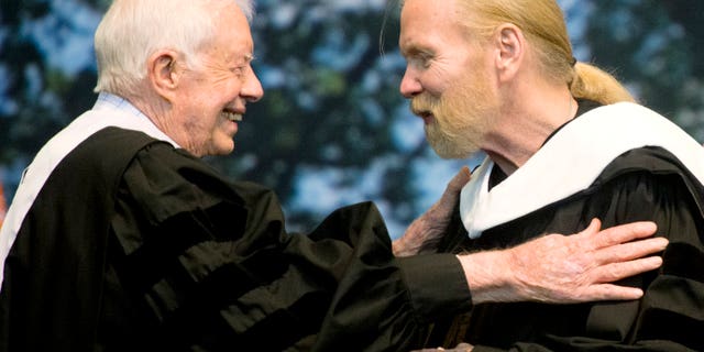 Jimmy Carter hugs Gregg Allman who received an honorary degree at Mercer University in Macon, Ga.
