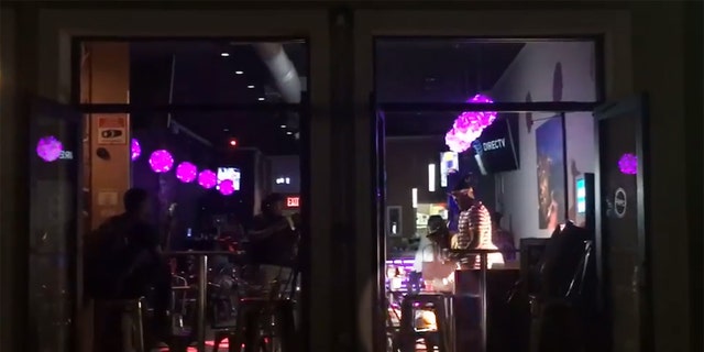 In footage taken by a passerby, some men inside the restaurant can be seen throwing what appears to be money on the women.