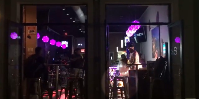 In footage taken by a passerby, some men inside the restaurant can be seen throwing what appears to be money on the women.