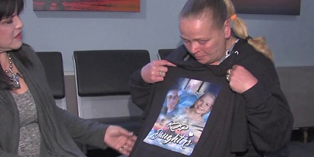 Cherri West holds up a tee-shirt that shows her two murdered daughters, Casey Eaton and 10-year-old Pamela Butler, with the phrase, "R.I.P Daughters."