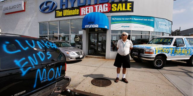 Aug. 24, 2009: A man looks at a car advertising the last day of the "Cash For Clunkers" auto rebates program outside a Hyundai dealership.