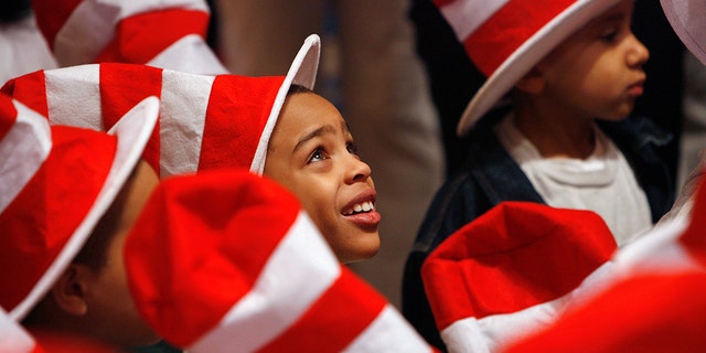 Children listen to tennis star Serena Williams read Dr. Seuss books to children during "Read Across America Day" to commemorate the 50th birthday of the "Cat In The Hat" character at the New York Public Library in New York, March 2, 2007. Recently, the Dr. Seuss museum in Massachusetts agreed to remove a mural after complaints of racism.