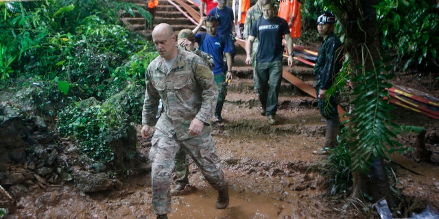 U.S. Special Operations Command Pacific Search and Rescue team personne; walk out of a cave where young soccer team and their coach are believed to be missing, Thursday, June 28, 2018, in Mae Sai, Chiang Rai province, in northern Thailand.