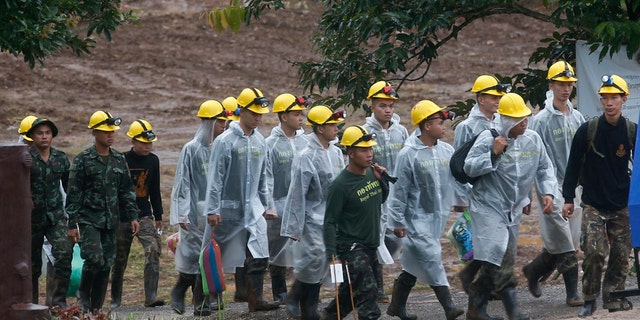 Rescuers walk toward the entrance to a cave complex where five were still trapped, in Mae Sai, Chiang Rai province, northern Thailand Tuesday, July 10, 2018.